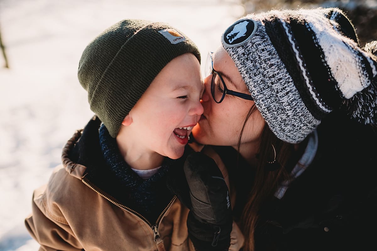 kisses from mom during snowy family photo session