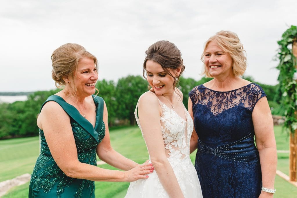 bride getting ready with bridesmaids outside on the golf course