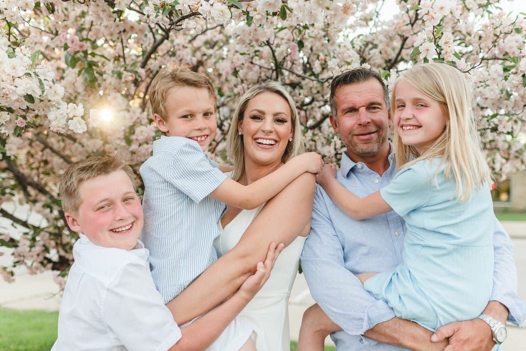 family photos in front of pink flowering fruit tree