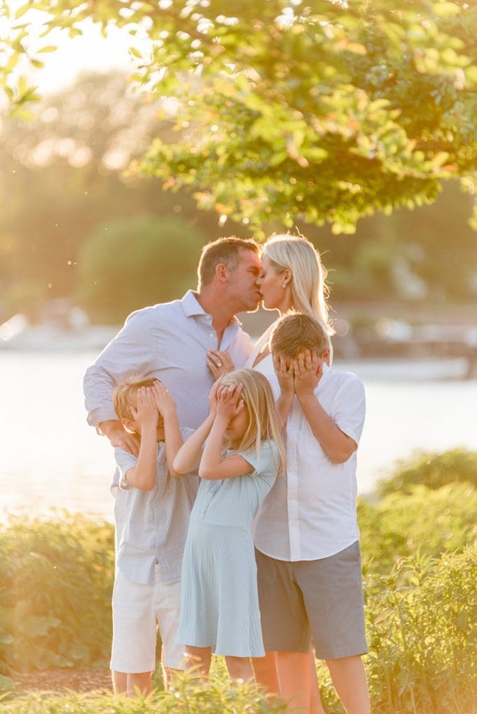 parents kissing and kids covering eyes pose