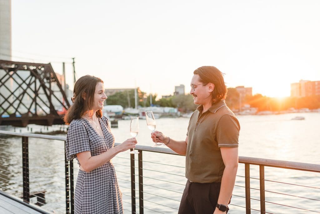 popping champagne at engagement session at sunset