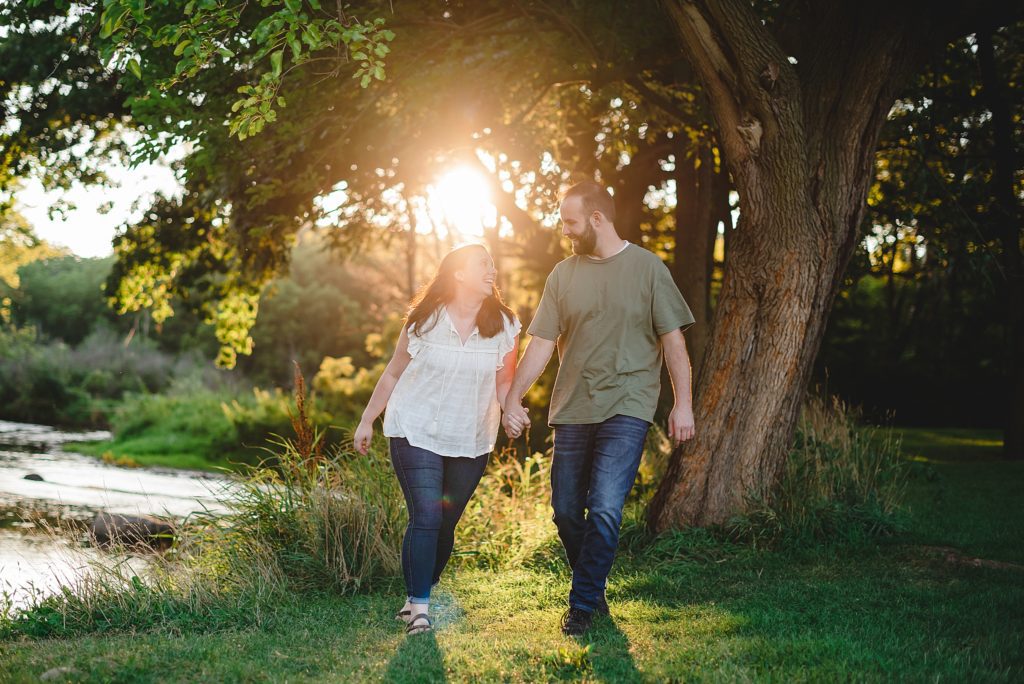 engagement session walking with sun behind them