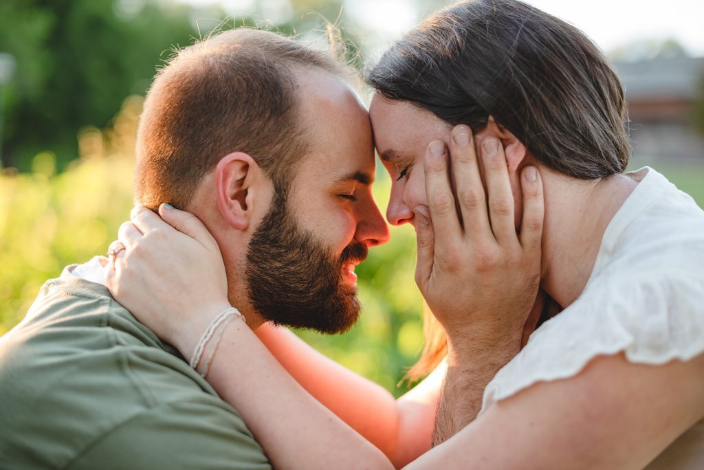 engaged couple holding each others face
