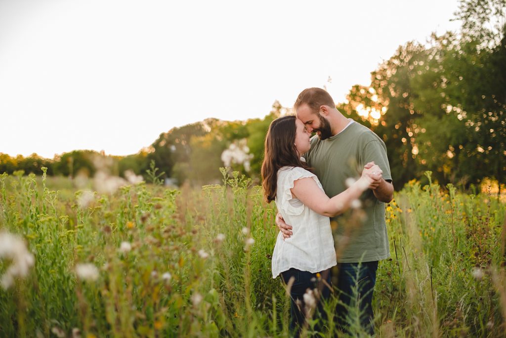 engaged couple dancing in field of wildflowers 