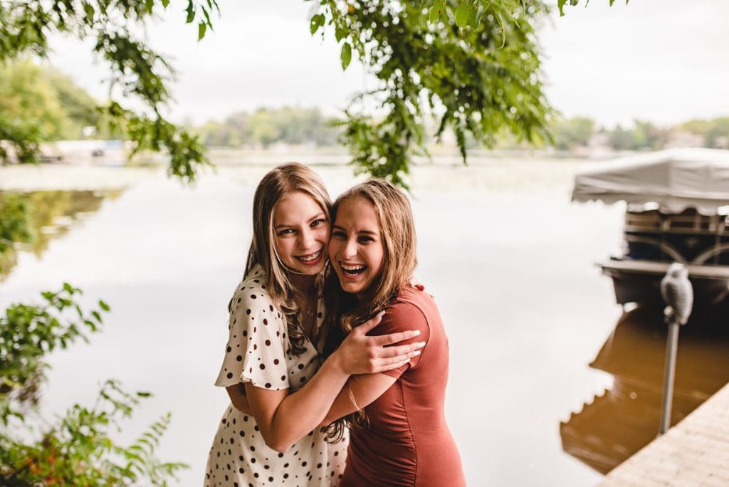 sisters hugging by the lake