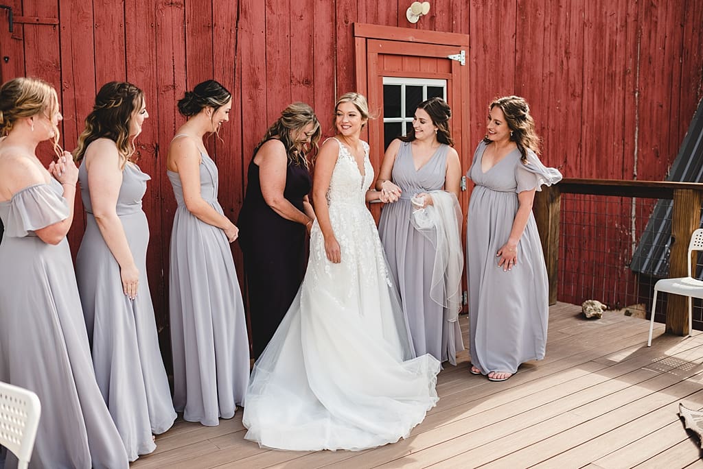 bride getting dressed outside of barn