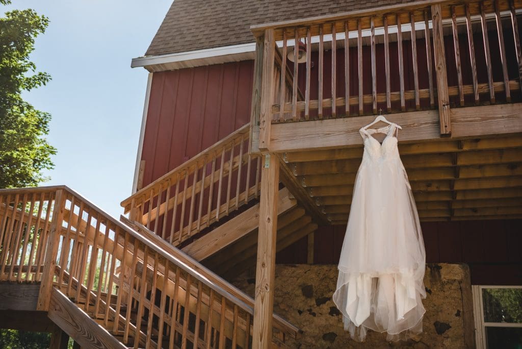 wedding dress hanging from wooden stairs outside