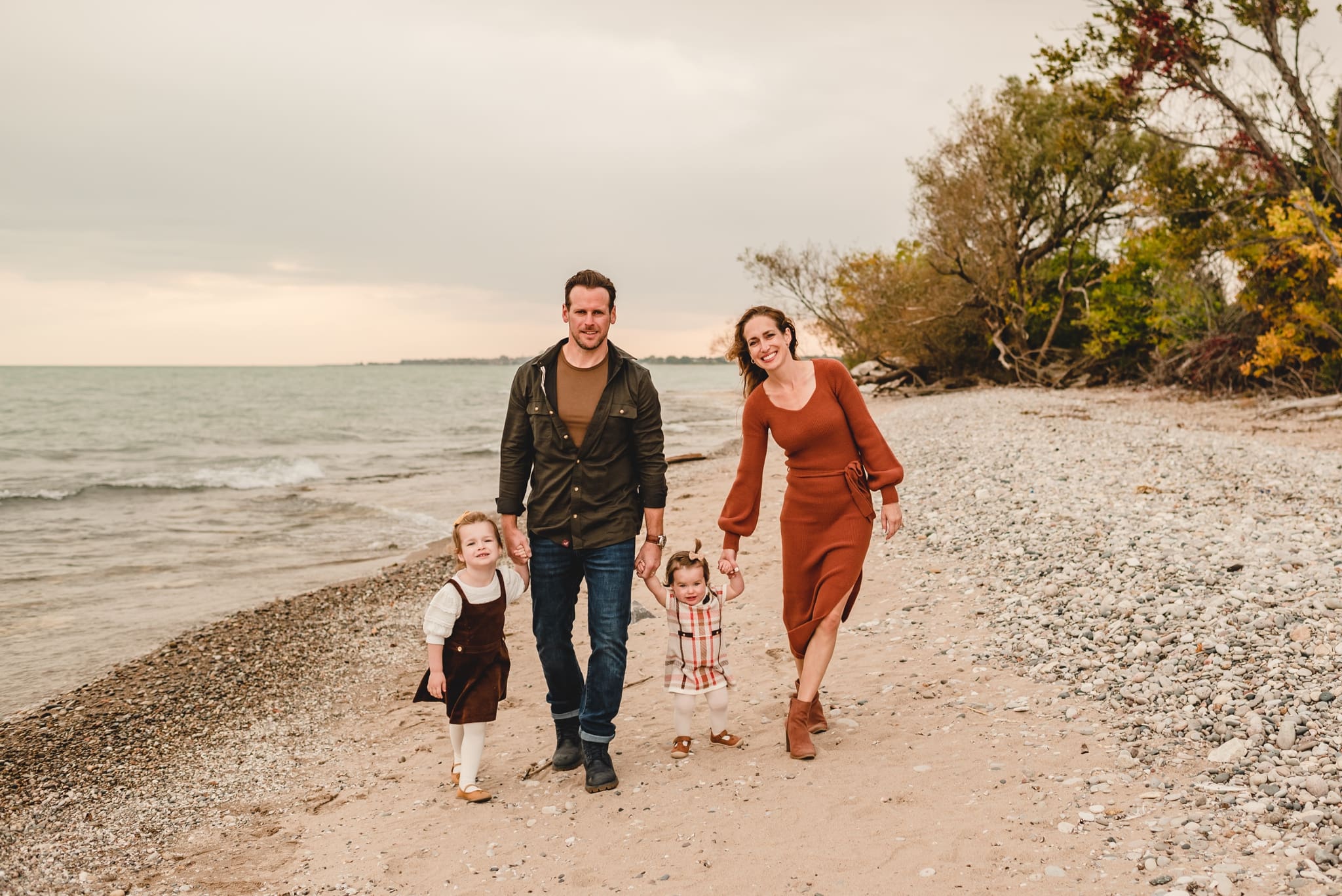 family walking together on lake michigan at wind point lighthouse in racine