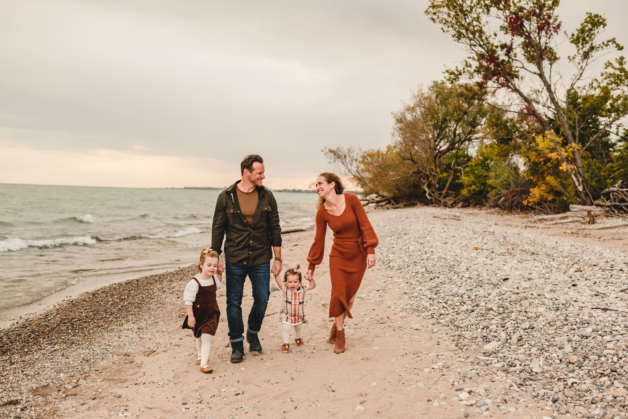 family walking together on lake michigan at wind point lighthouse in racine