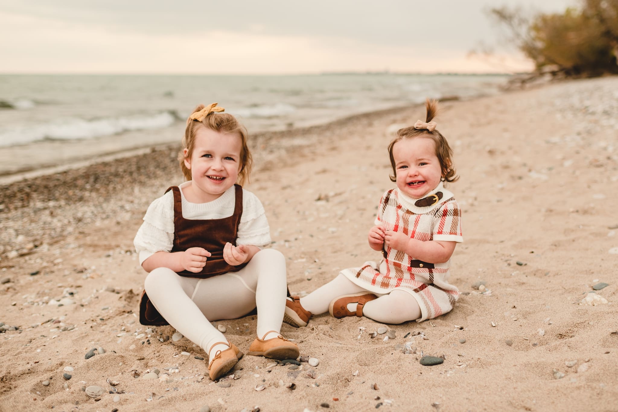 sisters sitting on the beach on lake michigan