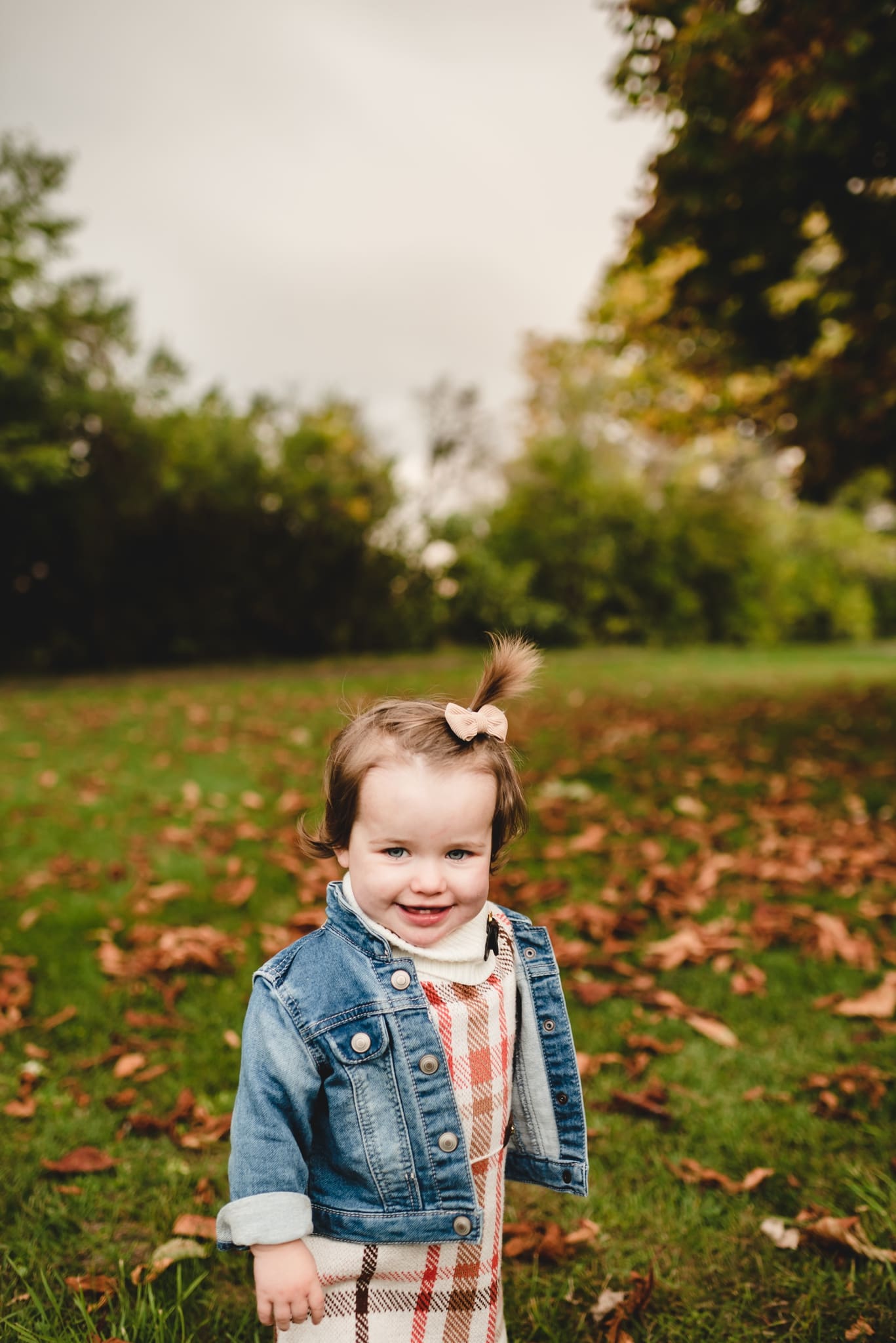 18 month old wearing plaid jumper and jean jacket