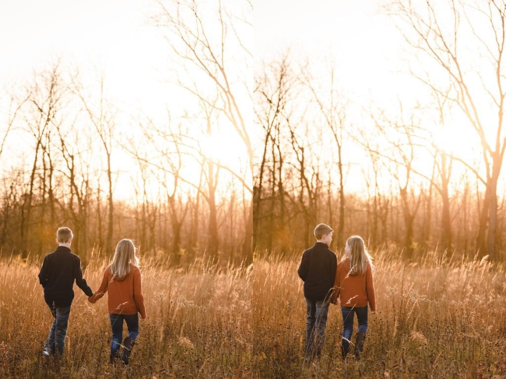 siblings holding hands and running together in a field for family photos