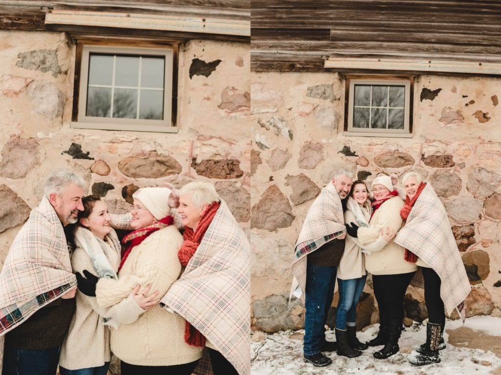 family wrapped in plaid quilt for winter photo session