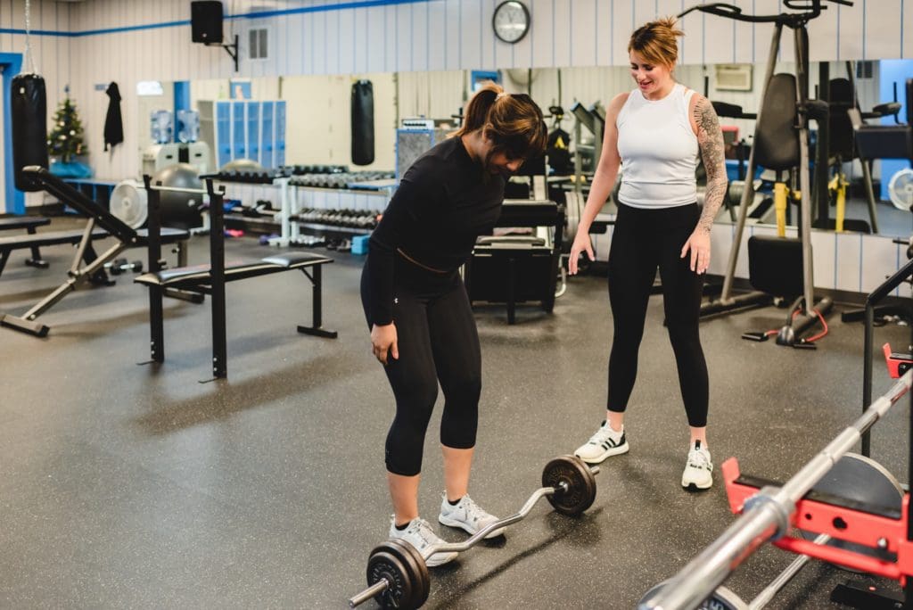 woman trainer showing woman how to do a dead lift