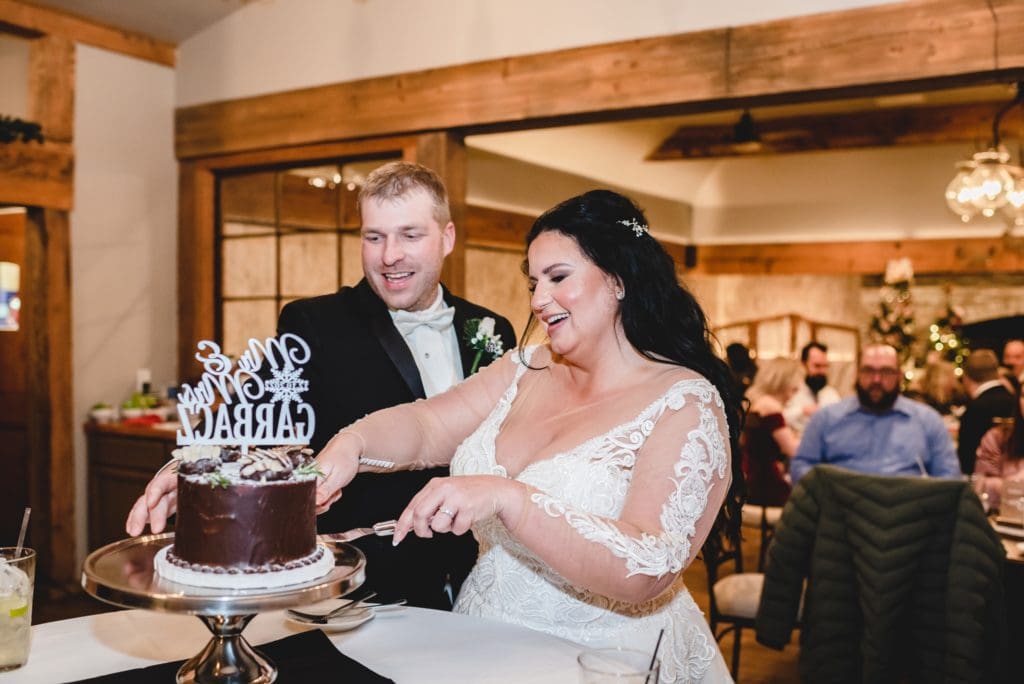 bride and groom cutting single layer chocolate wedding cake by sweetspot bakery in whitewater wisconsin