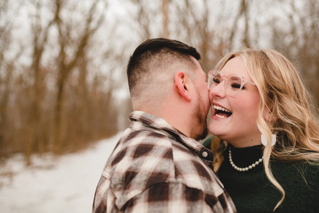 man whispering something funny into fiance's ear