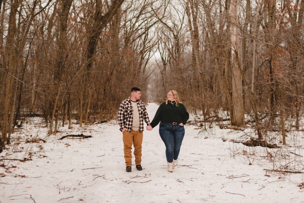 couple walking together in the snow for engagement photos