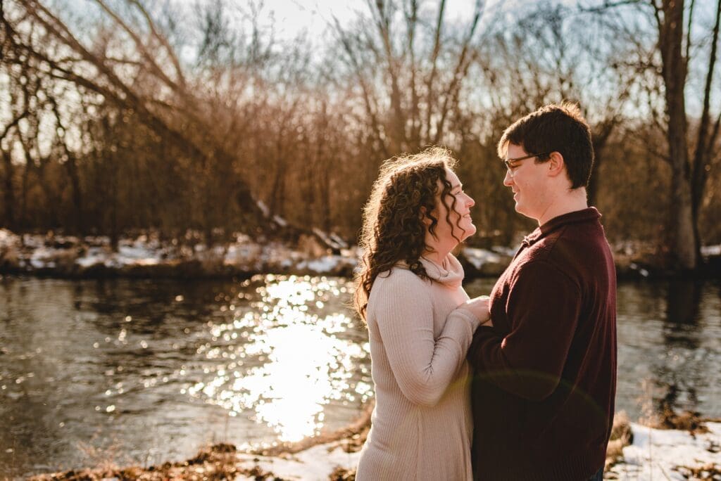 engagement photo of backlit couple holding hands together