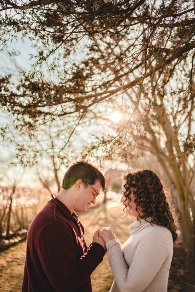 engagement photo of backlit couple holding hands together