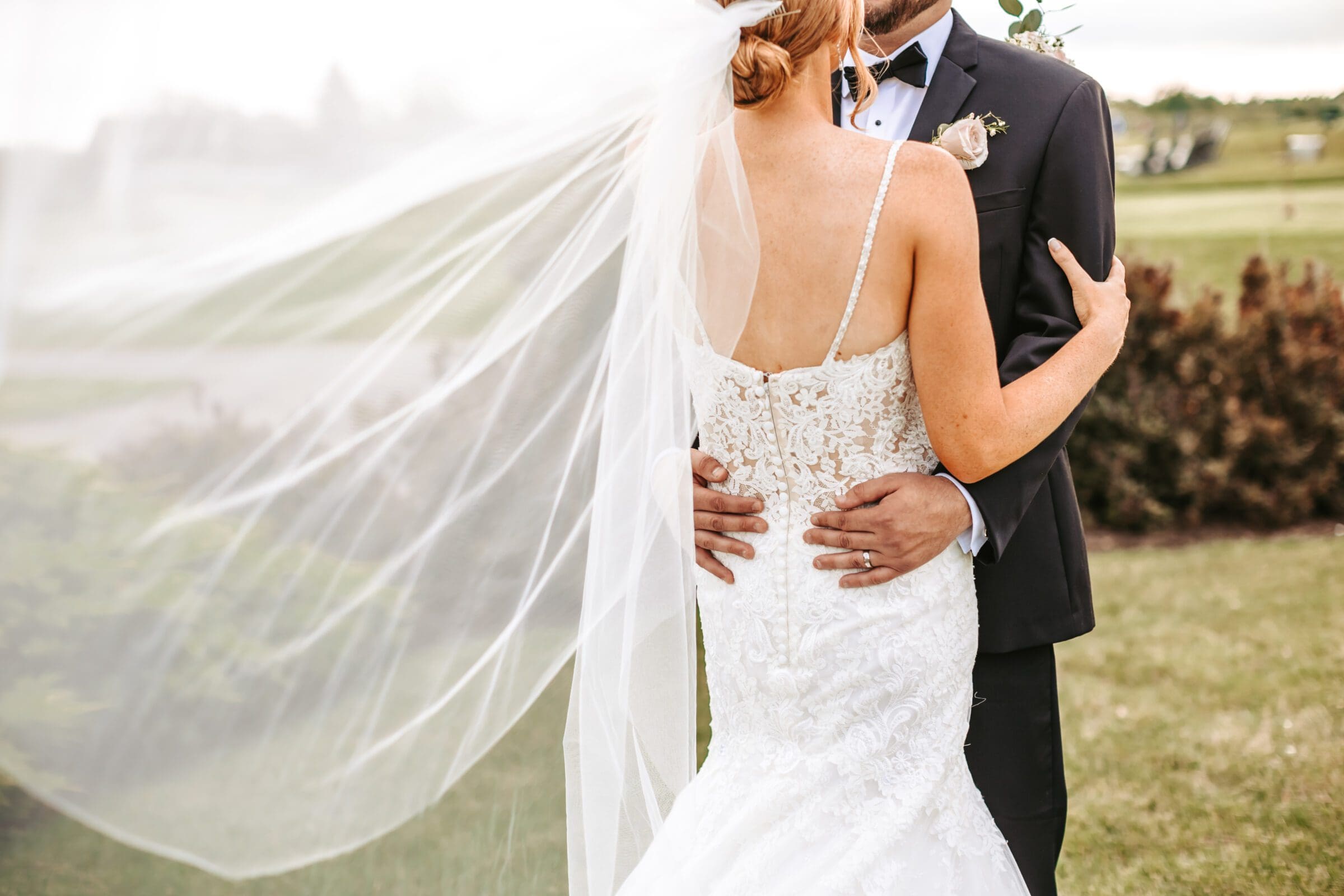 Cropped image of bride and groom from behind