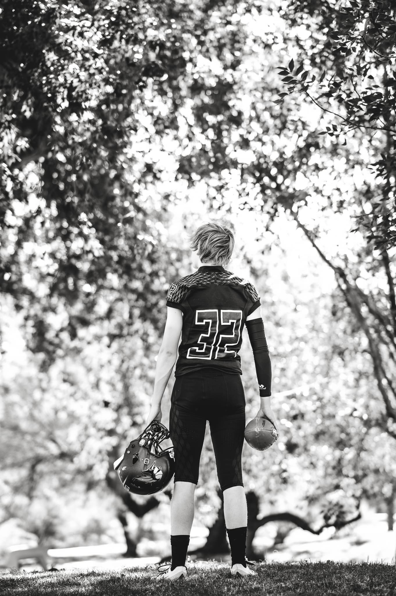 football player holding ball and helmet